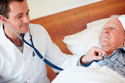 Doctor examining a senior man\'s heart beat