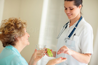 Young nurse giving a health pill to a patient