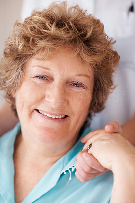 Closeup of a happy old woman holding a nurse\'s hand