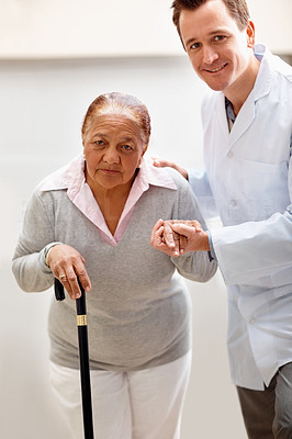 Young doctor helping a senior patient to walk