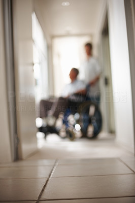 Blur image of a nurse with patient on wheel chair at hospital
