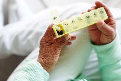 Old woman holding a medicine box , focus on the pills