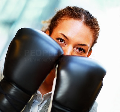 Business woman with her face covered by boxing gloves