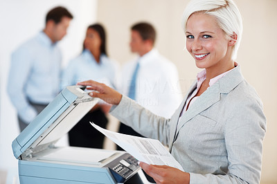 Happy businesswoman using the photo copy machine