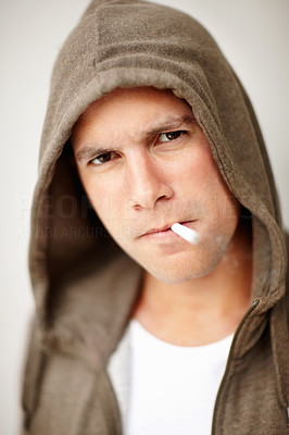 Middle aged man in a hooded smoking a cigarette