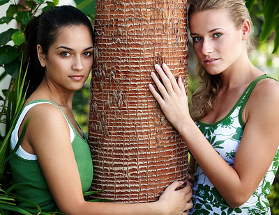 Beautiful teenage girls holding a tree bark in a park