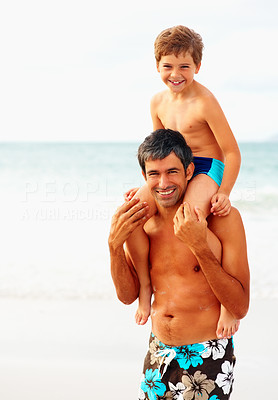 Father carrying his son on the shoulders while on the beach