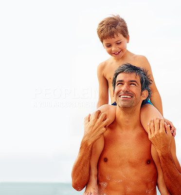 Man carrying his son on the shoulders while at the beach