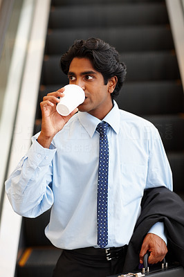 Asian business executive looking away while having a cup of tea