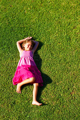 Sweet little girl resting on the grass on a sunny day