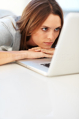 Lovely young lady lying on floor looking at the laptop