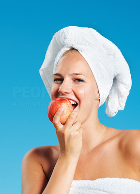 Woman in towel eating apple
