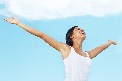Excited young female with outstretched hands against sky