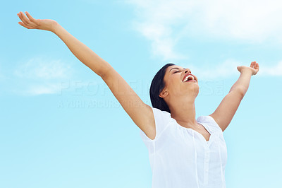 Joyful young female spreading her arms under the sky