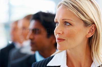 Business woman looking away while in line with colleagues