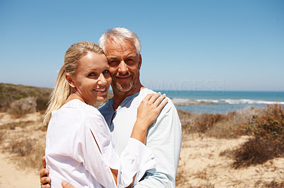 A mature couple hugging on a sunny day at the beach