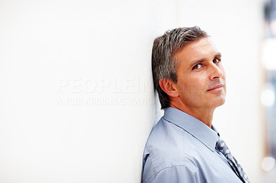 Portrait of a tired business man resting against on the wall