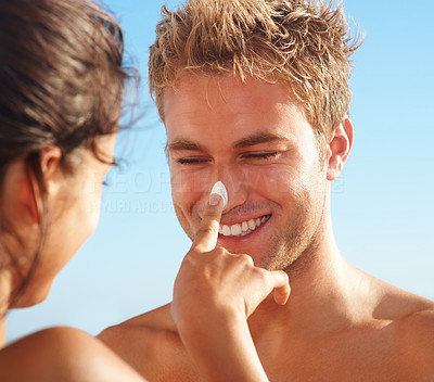 Female having fun by applying cream on man\'s nose