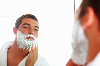 A young man in the bathroom preparing to shave.