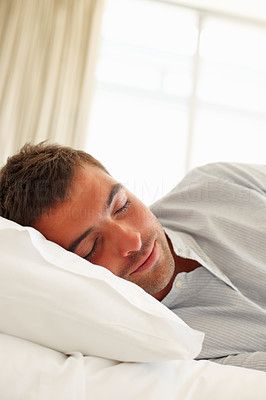 Happy young man sleeping in bed