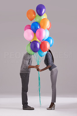 Stealing a kiss behind the balloons
