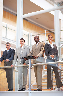 Successful business team standing by a railing