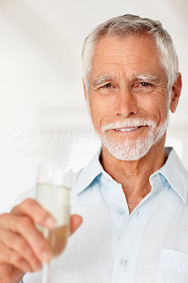 Old man holding a glass of champagne on a background