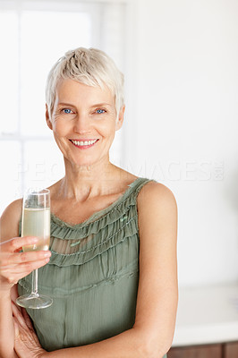 Elderly woman holding a glass of champagne, smiling