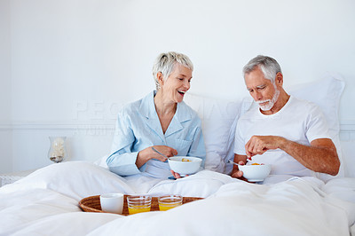 Old couple having breakfast while still in bed