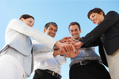 Business people with their hands on top of each other
