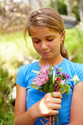 Cute young girl with a bunch of flowers at a forest