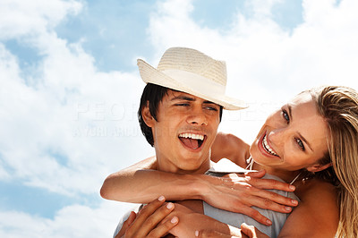 Cute young couple having fun with the blue sky as the background