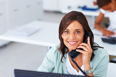 Beautiful business woman speaking on the phone at work
