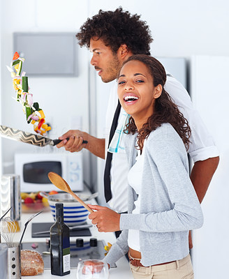 Happy young couple preparing food together at home