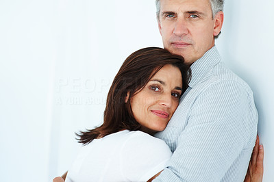 Happy mature couple hugging each other over a white background