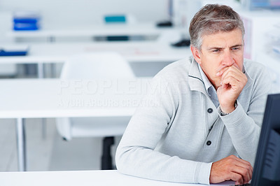 Mature business man looking at computer screen and thinking