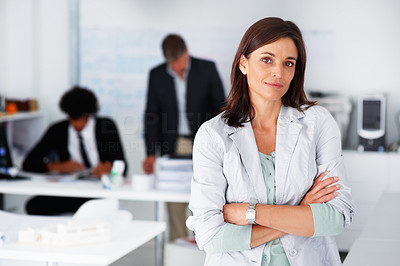 Business woman with her hands folded with business colleagues working at the back