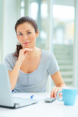 Beautiful young female sitting with coffee cup and laptop
