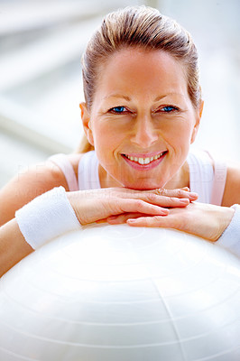 Closeup of happy fit mature female with a fitness ball