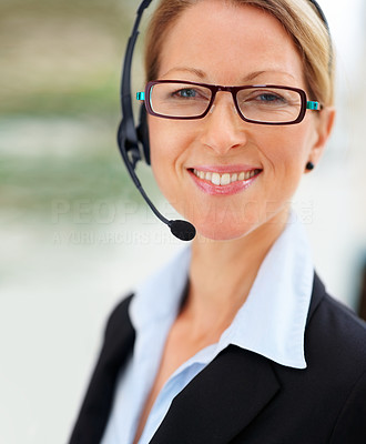 Closeup of a mature happy business woman using headset and smiling