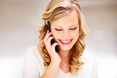 Closeup of a happy young woman speaking on a mobile