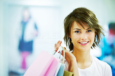 Cute young woman holding a shopping bags at a store