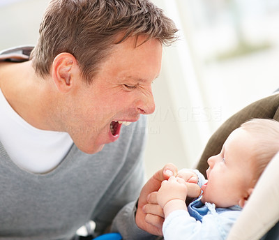 Happy young father making a funny face at his baby