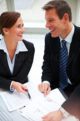 Portrait of smiling business people discussing over paper work
