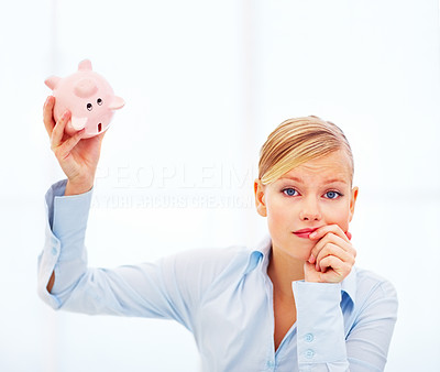 Unhappy woman holding empty piggybank over white background