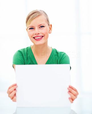 Young smiling girl holding a blank page over white background