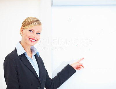 Portrait of beautiful young businesswoman pointing at blank board