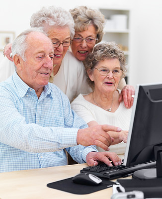 Elderly people working together on computer