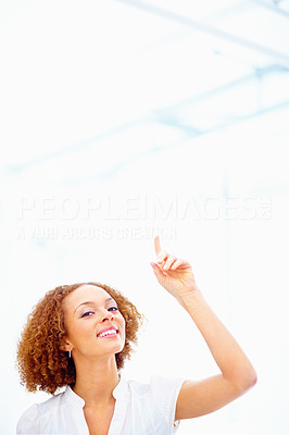 Business woman smiling and pointing up at copyspace