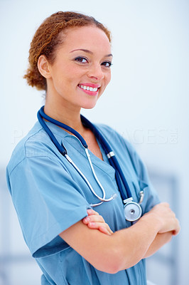 Closeup of young confident doctor standing with arms folded